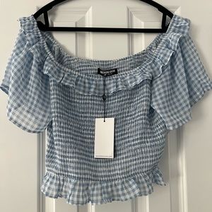 New off the shoulder cropped frilly top. Stretch in the breast area.
